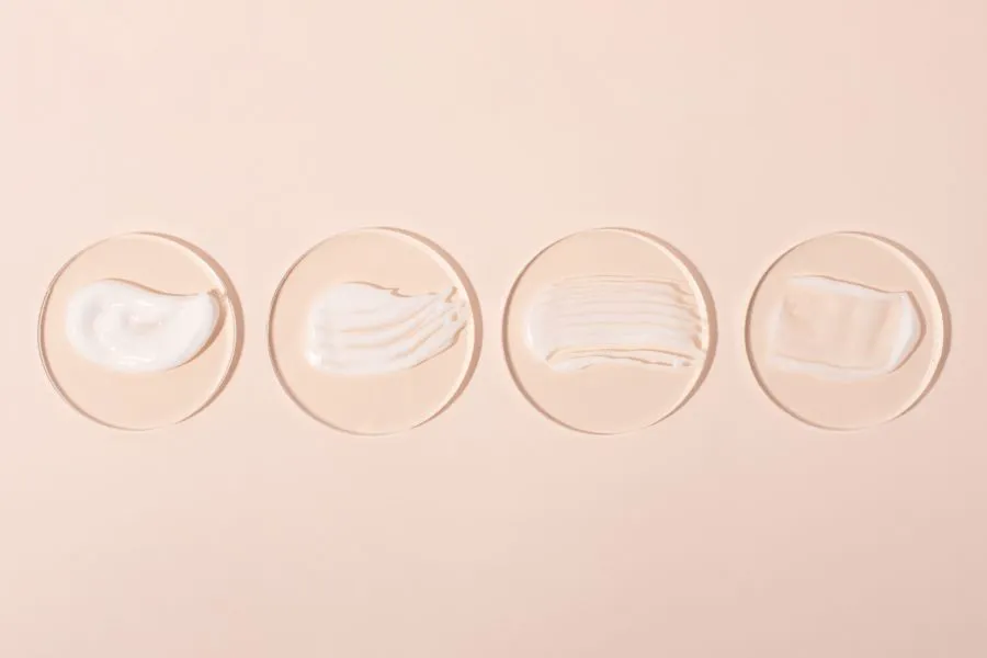 Four pieces of glass with different lotions on them.